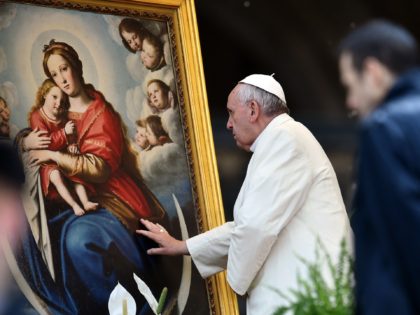Pope Francis touches a painting depicting Virgin Mary at the end of his weekly general audience in St Peter's square at the Vatican on March 25, 2015. AFP PHOTO / GABRIEL BOUYS (Photo credit should read GABRIEL BOUYS/AFP via Getty Images)