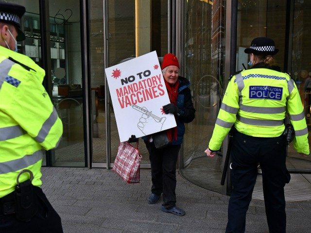 Demonstrators remonstrate with police officers as they hold placards during an anti-vaccine demonstration outside the offices of the Bill and Melinda Gates foundation in central London on November 24, 2020. - British Prime Minister Boris Johnson told MPs that thanks to a potential vaccine the escape route is in sight …