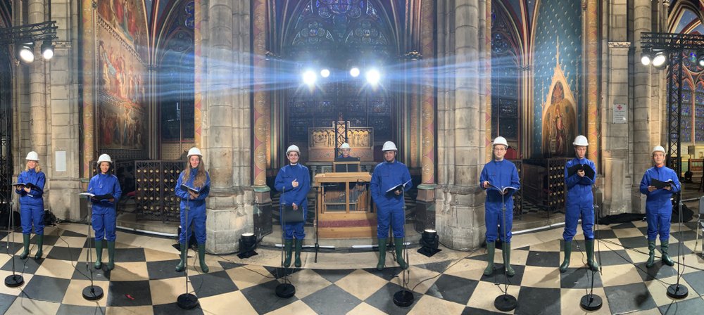 In this photo provided by Maitrise Notre-Dame de Paris, the Notre Dame Cathedral choir, wearing hard hats and protective suits, record a Christmas concert on Saturday, Dec. 19, 2020, inside Notre Dame Cathedral in Paris. The concert will be broadcasted on French television on Christmas. (MSNDP/Musique Sacree à Notre-Dame de Paris via AP)
