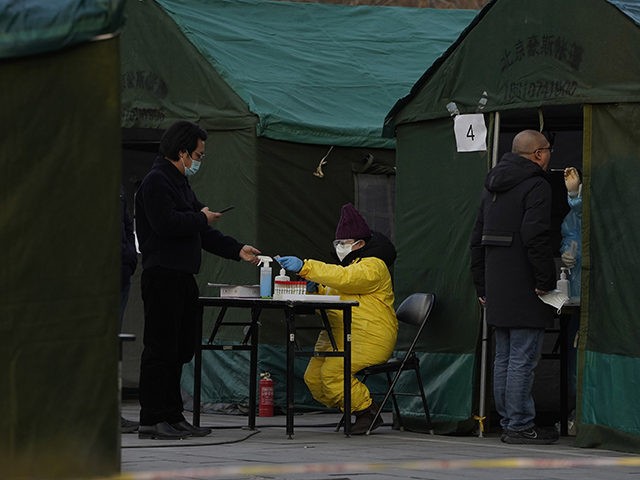 Residents line up for coronavirus tests at tents set up on the streets of Beijing on Sunday, Dec. 27, 2020. Beijing has urged residents not to leave the city during the Lunar New Year holiday in February, implementing new restrictions and mass testings after several coronavirus infections last week. (AP …