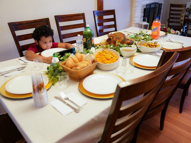 Evan Zayas waits at the dining room table where an empty place setting for his recently de