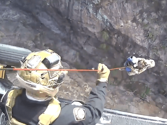 A CBP AMO Black Hawk aircrew and a BORSTAR Border Patrol agent rescue an injured migrant woman and a male companion in the Arizona wilderness. (Video Screenshot/U.S. Customs and Border Protection/Air and Marine Operations)