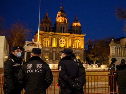 Policemen stand in front of St. Joseph's Church during a mass on Christmas eve in Beijing
