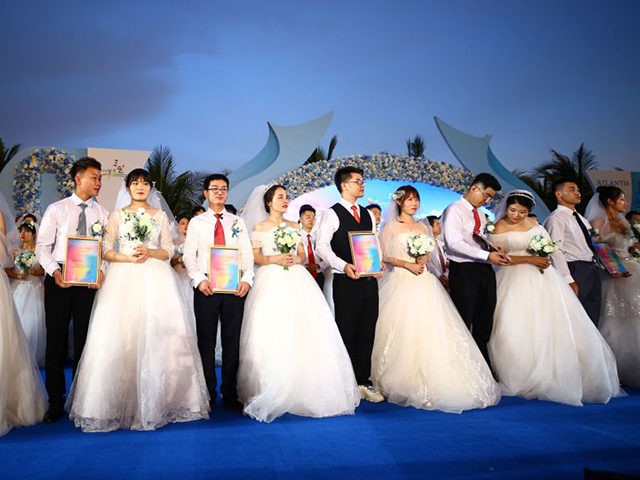 This photo taken on June 6, 2020 shows couples during a mass wedding ceremony for couples who had delayed their weddings to work on the frontlines of the fight against the COVID-19 coronavirus, in Sanya, on China's southern Hainan island. - One hundred couples from across China took opart in …