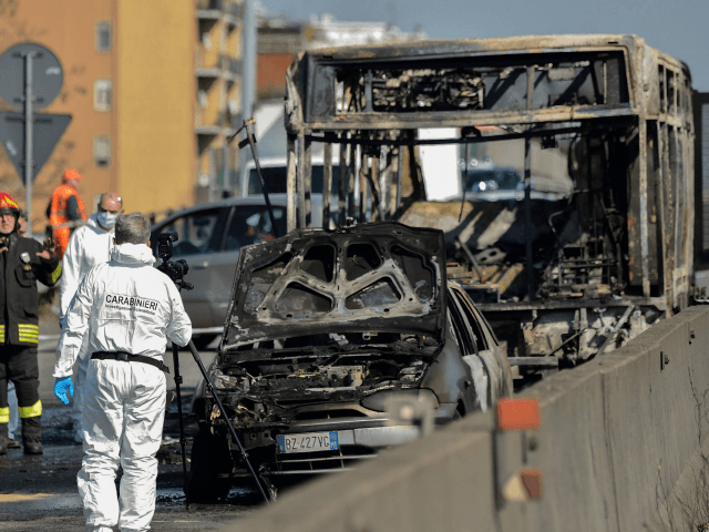 TOPSHOT - Forensic policemen and firefighters work by the wreckage of a school bus that was transporting some 50 children on March 20, 2019 after it was torched by the bus' driver, in San Donato Milanese, southeast of Milan. - Italian police rescued some 50 children on March 20, 2019 …