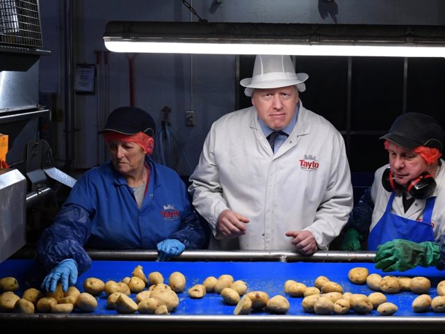 ARMAGH, NORTHERN IRELAND - NOVEMBER 07: Prime Minister Boris Johnson (C) helps quality con