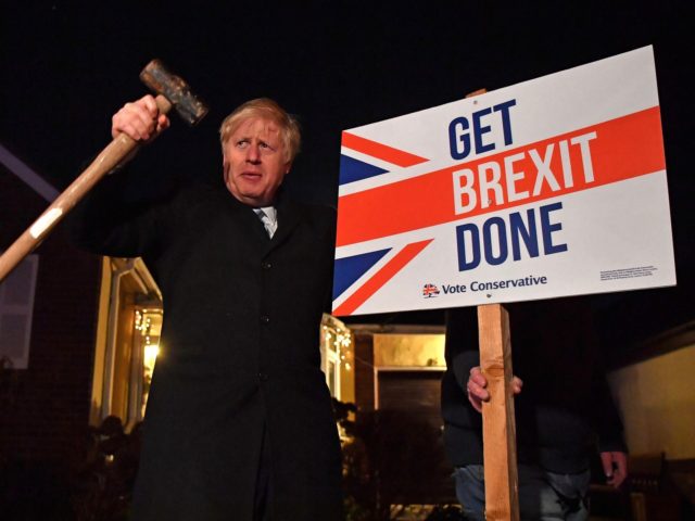 TOPSHOT - Britain's Prime Minister and Conservative party leader Boris Johnson poses after hammering a "Get Brexit Done" sign into the garden of a supporter, with a sledgehammer as he campaigns with his team in Benfleet, east of London on December 11, 2019, the final day of campaigning for the …