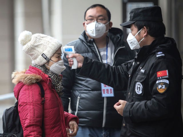 WUHAN, CHINA - JANUARY 22: (CHINA OUT) Security personnel check the temperature of passengers in the Wharf at the Yangtze River on January 22, 2020 in Wuhan, Hubei province, China. A new infectious coronavirus known as "2019-nCoV" was discovered in Wuhan as the number of cases rose to over 400 …