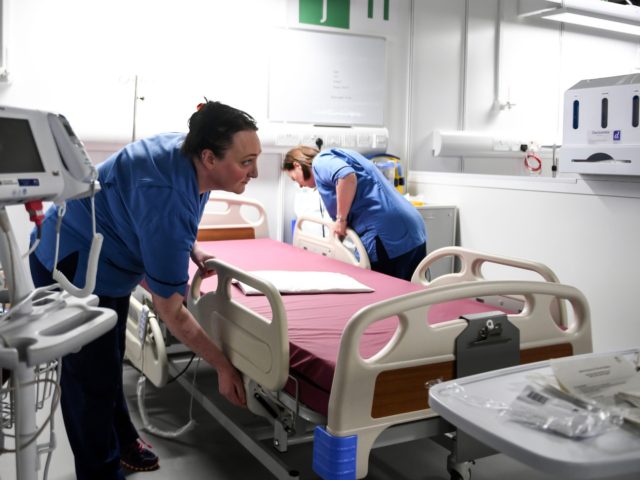 Staff prepare beds ready for use inside the NHS Louisa Jordan field hospital, set up in the main hall at the Scottish Events Campus (SEC) in Glasgow on April 20, 2020, during the novel coronavirus COVID-19 pandemic. - "From Monday 20 April 2020, the hospital will be equipped and clinically …