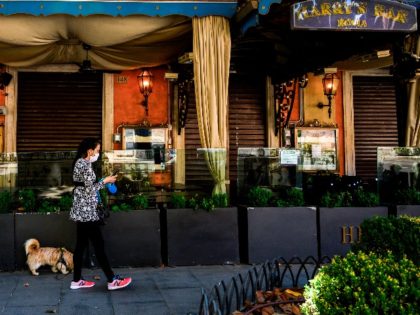 A woman walks her dog past a closed Harry's Bar on Via Veneto in central Rome on May 21, 2020, as the country eases its lockdown aimed at curbing the spread of the COVID-19 infection, caused by the novel coronavirus. - The reopening of Italy's restaurants, cafes and storefronts earlier …
