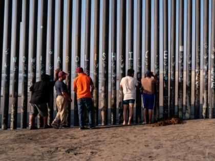 Men look through the US-Mexico border fence in Playas de Tijuana, Baja California state, Mexico, on October 3, 2020, amid the COVID-19 coronavirus pandemic. - This weekend the beach in Playas de Tijuana reopened with restrictions to visitors, after it was closed as a preventive measure to avoid the spread …