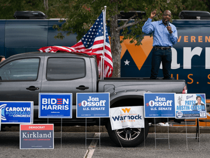 Democratic Senate candidate Reverend Raphael Warnock speaks at a rally on October 24, 2020, in Duluth, Georgia. - Neighbors and volunteers are handing out water and snacks to the masked voters waiting patiently in line to cast their ballots on a hot October day in the Atlanta suburb of Smyrna. …