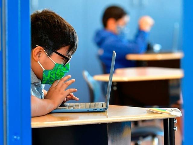 Students work on their laptop computers at St. Joseph Catholic School in La Puente, Califo