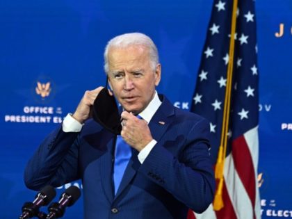 US President-elect Joe Biden, removes his facemask, as he announces his economic team at T
