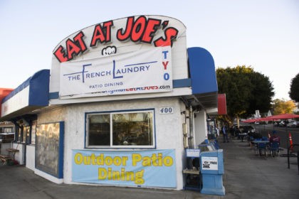 An employee works inside the kitchen at "Eat At Joe's", which has remained open for outdoor dining in defiance of reimposed Los Angeles County Covid-19 restrictions in order to keep employees paid during the holidays, in Redondo Beach, California, December 1, 2020. - Owner Alex Jordan hung a "French Laundry" …