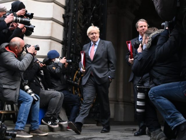 TOPSHOT - Britain's Prime Minister Boris Johnson (C) returns to 10 Downing Street in