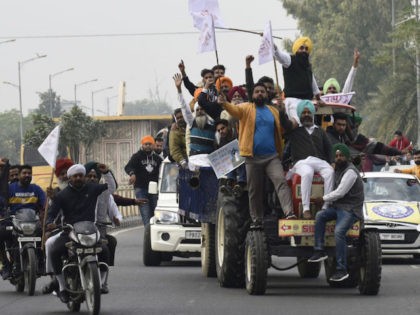 Activists of the National Students' Union of India (NSUI) shout slogans against India's Prime Minister Narendra Modi from atop a tractor during a protest in support of a nationwide general strike called by farmers to protest against the recent agricultural reforms in Amritsar on December 8, 2020. (Photo by Narinder …