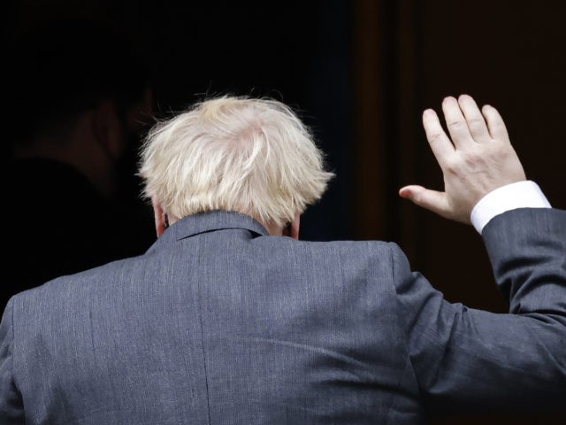 Britain's Prime Minister Boris Johnson waves as he returns to 10 Downing Street in ce