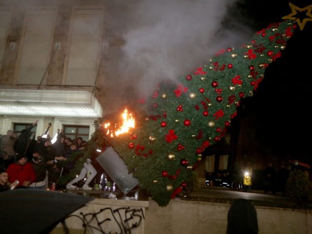 TOPSHOT - Protesters burn a Christmas tree in front of the Albanian Prime Minister buildin