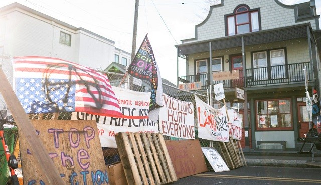 Layers of chainlink fence and wood block the North entry to the Red House on Mississippi Street on December 9, 2020 in Portland, Oregon. Police and protesters clashed during an attempted eviction Tuesday morning, leading protesters to establish a barricade around the Red House. (Photo by Nathan Howard/Getty Images)