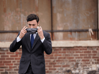U.S. Democratic Senate candidate Jon Ossoff puts his face mask back on after delivering remarks during a campaign rally with U.S. President-elect Joe Biden at Pullman Yard on December 15, 2020 in Atlanta, Georgia. Biden's stop in Georgia comes less than a month before the January 5 runoff election for …