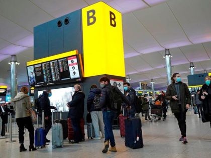 Travellers queue with their luggage in the departures hall at Terminal 2 of Heathrow Airport in west London on December 21, 2020, as a string of countries around the world banned travellers arriving from the UK, due to the rapid spread of a new, more-infectious coronavirus strain. - Prime Minister …