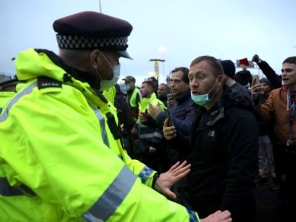DOVER, ENGLAND - DECEMBER 23: A man speaks to a police officer at the Port of Dover on December 23, 2020 in Dover, United Kingdom. Nearly 3,000 lorries were stranded around Kent after France banned all travel from the UK on Sunday, citing concerns over a new variant of covid-19. …