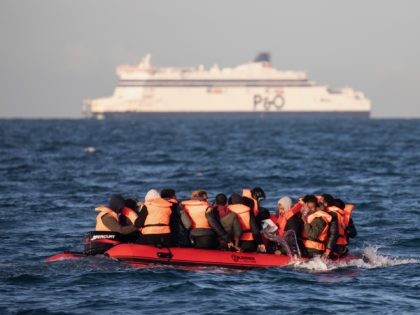 AT SEA, UNITED KINGDOM - SEPTEMBER 07: Migrants packed tightly onto a small inflatable boat bail water out as they attempt to cross the English Channel near the Dover Strait, the world's busiest shipping lane, on September 07, 2020 off the coast of Dover, England. Last Wednesday, more than 400 …