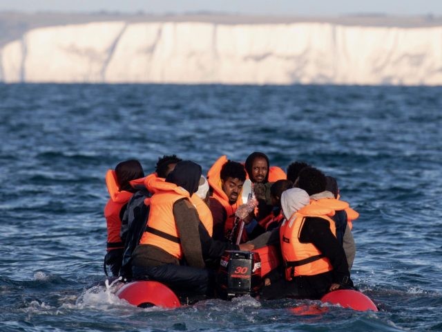 AT SEA, UNITED KINGDOM - SEPTEMBER 07: Migrants packed tightly onto a small inflatable boat attempt to cross the English Channel near the Dover Strait, the world's busiest shipping lane, on September 07, 2020 off the coast of Dover, England. Last Wednesday, more than 400 migrants made the journey from …