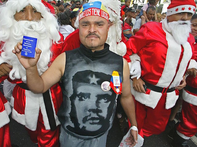 A supporter of President Hugo Chavez holds a copy of the constitution by a man dressed as