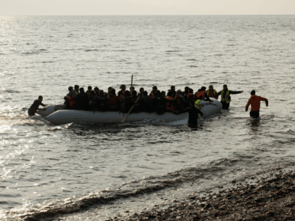 Refugees and migrants on a rubber boat arrive at the Greek island of Lesbos early on March
