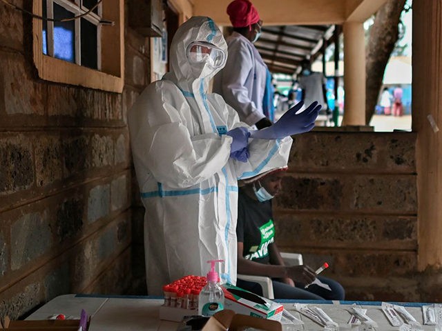 A health worker dressed in personal protective equipment (PPE) prepares to test someone during a mass testing for COVID-19 coronavirus provided free of charge by the Kenyan government in the Kibera slum in Nairobi on October 18, 2020. - The Nairobi Metropolitan Services (NMS) commenced a free COVID-19 coronavirus mass …