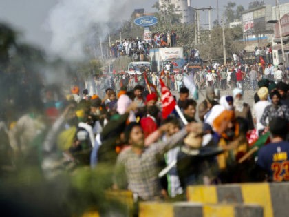 Protesting farmers shout slogans and face security officers at the border between Delhi an