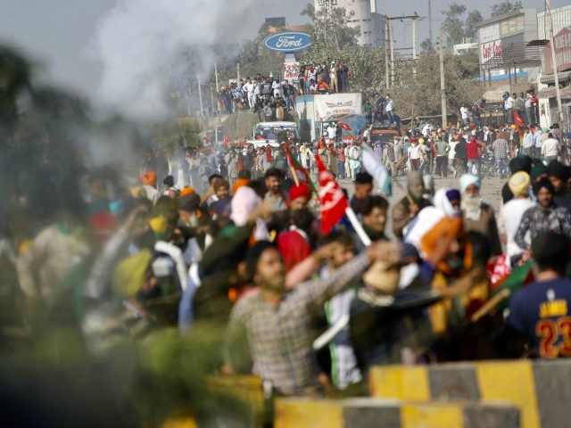 Protesting farmers shout slogans and face security officers at the border between Delhi and Haryana state, Friday, Nov. 27, 2020. Thousands of agitating farmers in India faced tear gas and baton charge from police on Friday after they resumed their march to the capital against new farming laws that they …