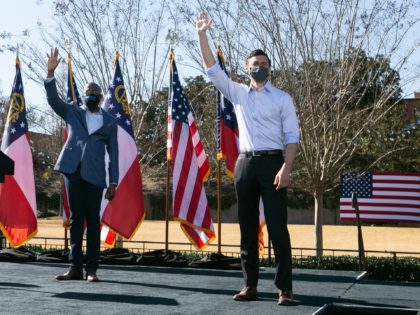 COLUMBUS, GA - DECEMBER 21: (left to right) Vice President-elect Kamala Harris with Georgia Democratic Senate candidates Rev. Raphael Warnock and Jon Ossoff wave to the crowd during a drive-in rally at Bibb Mill Event Center on December 21, 2020 in Columbus, Georgia. The visit by Vice President-elect Harris comes …