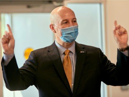 Nebraska Gov. Pete Ricketts wears a face mask during a tour of a new DMV service center in