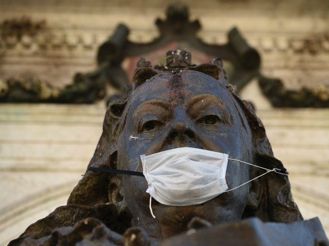 A mask used as a precaution against the novel coronavirus COVID-19 pandemic is seen on the statue of Queen victoria in Piccadilly Gardens, Manchester, northern England on March 20, 2020. - Britain's Prime Minister said Thursday that Britain could "turn the tide" on coronavirus within 12 weeks -- but only …