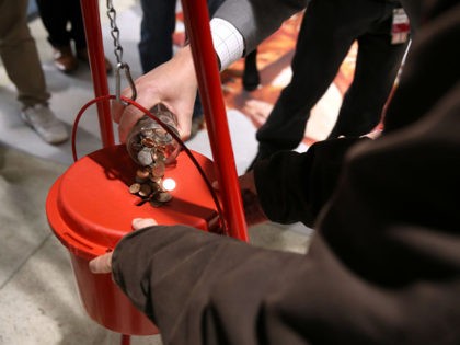 SAN FRANCISCO, CALIFORNIA - DECEMBER 03: BART Board President Bevan Dufty pours change into a Salvation Army red kettle at the Powell Street Bay Area Rapid Transit (BART) station on December 03, 2019 in San Francisco, California. The Salvation Army kicked off the Red Kettle "Partners for Change" campaign inside …