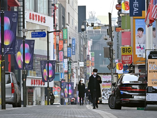 Masked pedestrians walk through the Myeongdong shopping district in Seoul on December 23, 2020, as South Korea banned gatherings of more than four people in the capital and surrounding areas amid a surge in cases of the COVID-19 coronavirus. (Photo by Jung Yeon-je / AFP) (Photo by JUNG YEON-JE/AFP via Getty Images)