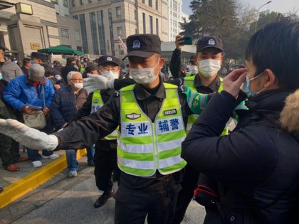 Police attempt to stop journalists from recording footage outside the Shanghai Pudong New