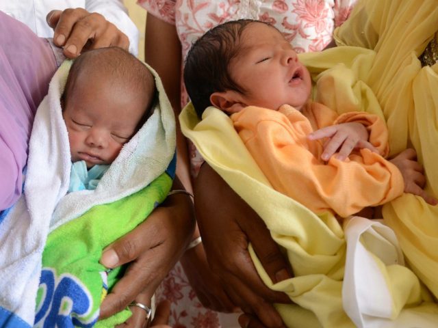 Workers with the Indian Red Cross Society hold abandoned baby boys found at a 'pangpura' (