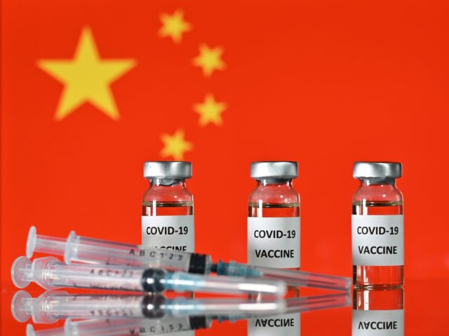 An illustration picture shows vials with Covid-19 Vaccine stickers attached, and syringes, with the national flag of China, on November 17, 2020. (Photo by JUSTIN TALLIS / AFP) (Photo by JUSTIN TALLIS/AFP via Getty Images)