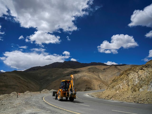 A man drives an excavator on the highway in Karakoram mountains connecting the Kashmir val