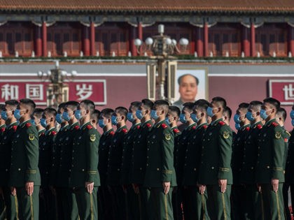 BEIJING, CHINA - OCTOBER 23: Chinese soldiers from the People's Liberation Army wear protective masks as they line-up before a ceremony marking the 70th anniversary of China's entry into the Korean War, on October 23, 2020 in Tiananmen Square outside the Great Hall of the People in Beijing, China. (Photo …