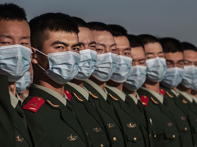 Chinese soldiers from the People's Liberation Army wear protective masks as they line-up a