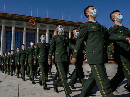 BEIJING, CHINA - OCTOBER 23: Chinese soldiers from the People's Liberation Army wear protective masks as they march after a ceremony marking the 70th anniversary of China's entry into the Korean War, on October 23, 2020 at the Great Hall of the People in Beijing, China. Chinese President Xi Jinping …