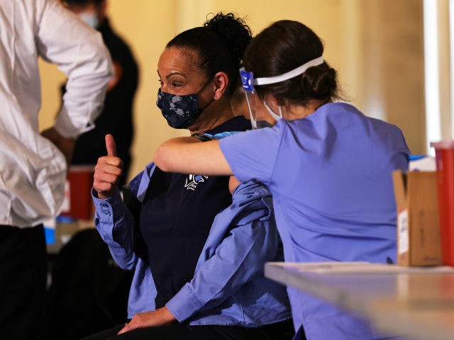 A member of FDNY EMS gives a thumbs up while receiving the coronavirus (COVID-19) vaccine