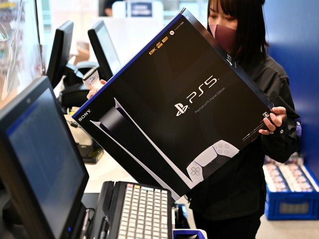 An employee prepares the new Sony PlayStation 5 gaming console for a customer on the first day of its launch, at an electronics shop in Kawasaki, Kanagawa prefecture on November 12, 2020. (Photo by CHARLY TRIBALLEAU / AFP) (Photo by CHARLY TRIBALLEAU/AFP via Getty Images)