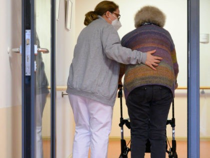 A elderly care nurse helps a resident in the retirement home St. Barbara of German welfare