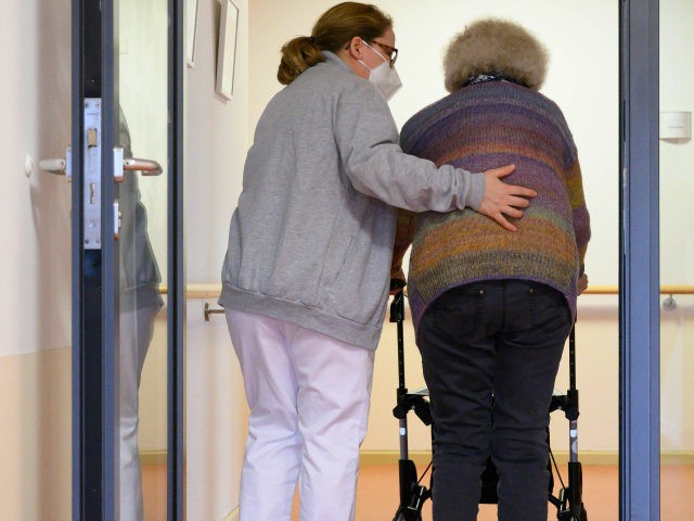 A elderly care nurse helps a resident in the retirement home St. Barbara of German welfare